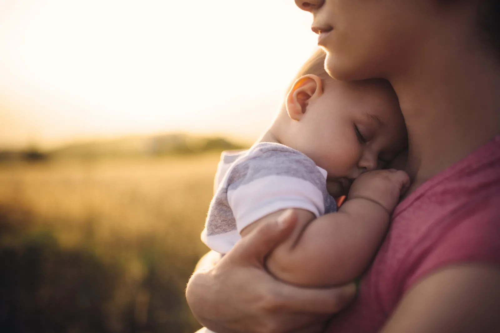 Bébé endormi dans les bras de sa maman